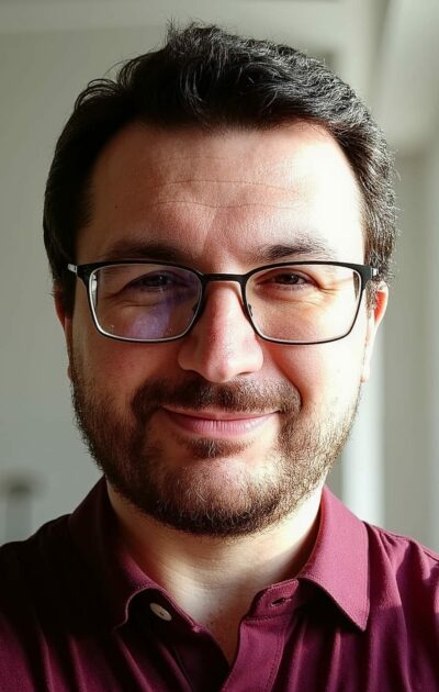 A picture of Matteo Greco, CTO and software engineer, in a burgundy shirt, looking straight into the camera and smiling